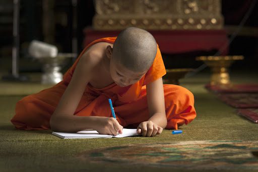 Young Buddhist monks doing a school work. VolunteerForever